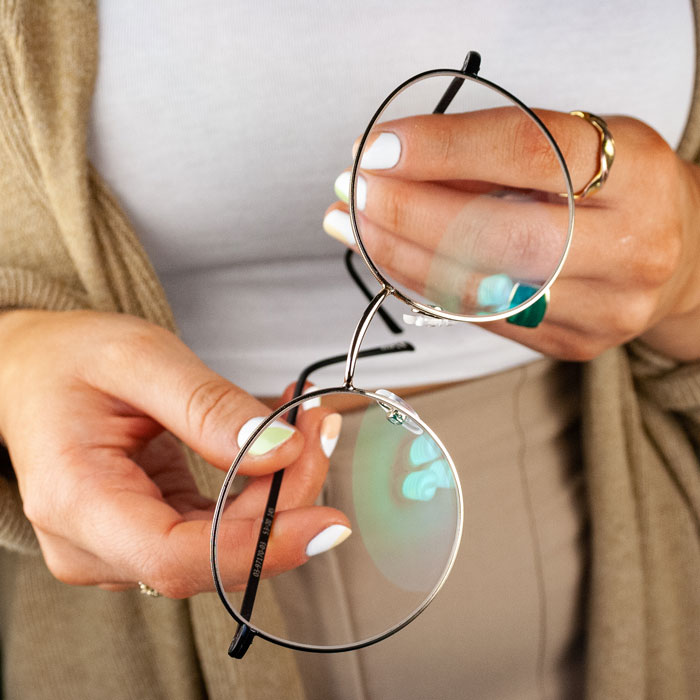 Du hast deine Lieblingsbrille gefunden? Super, dann bestell deine neue Brille direkt in deiner Sehstärke Eine Frau hält die FRAIMS Celine
